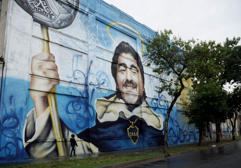 &copy; Reuters. FOTO DE ARCHIVO: Un peatón pasa por delante de un mural que representa a la difunta leyenda del fútbol Diego Armando Maradona en La Boca, en el primer aniversario de su muerte, Buenos Aires, Argentina 25 de noviembre de 2021. REUTERS/Mariana Nedelcu NO 