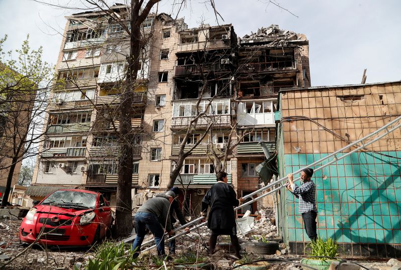 &copy; Reuters. سكان يستخدمون سلما متنقلا قرب عمارة سكنية لحقت بها أضرار شديدة جراء القصف في مدينة ماريوبول الساحلية بجنوب أوكرانيا يوم 25 ابريل نيسان 2022. تص