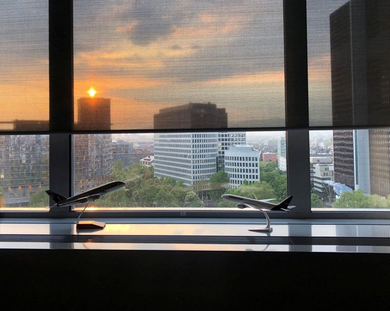 © Reuters. The sun sets behind an office window with models of Lufthansa and Qatar Airways planes, in Frankfurt, Germany, May 4, 2022. REUTERS/Zuzanna Szymanska