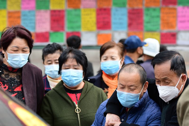 &copy; Reuters. People wearing face masks to prevent the spread of the novel coronavirus disease (COVID-19) look at job advertisements at the West Coast New Area in Qingdao, Shandong province, China April 8, 2020.  China Daily via REUTERS  