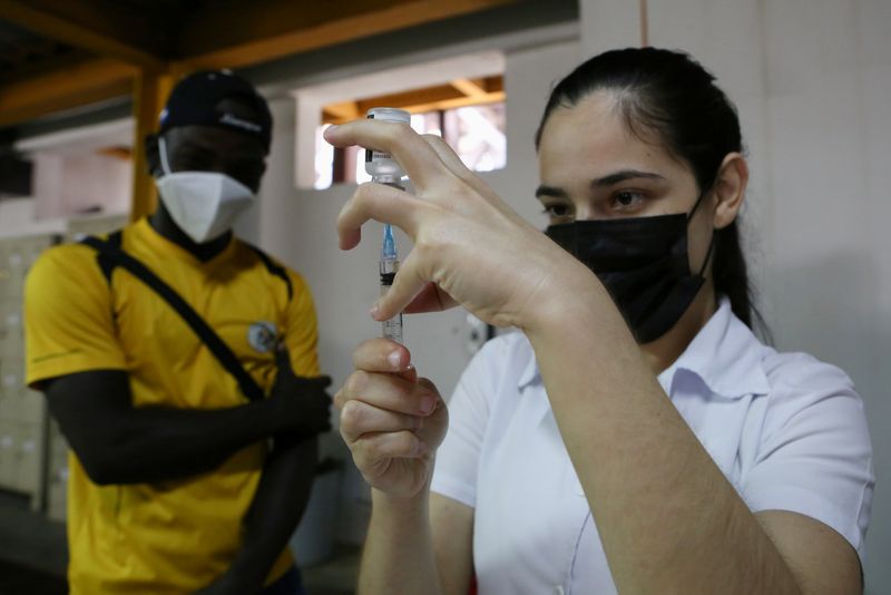 &copy; Reuters. A Costa Rican health care worker prepares a vaccine dose to administer to a Haitian migrant as part of a vaccination campaign against the coronavirus disease (COVID-19) targeting migrants regardless of their legal status, in San Jose, Costa Rica October 1