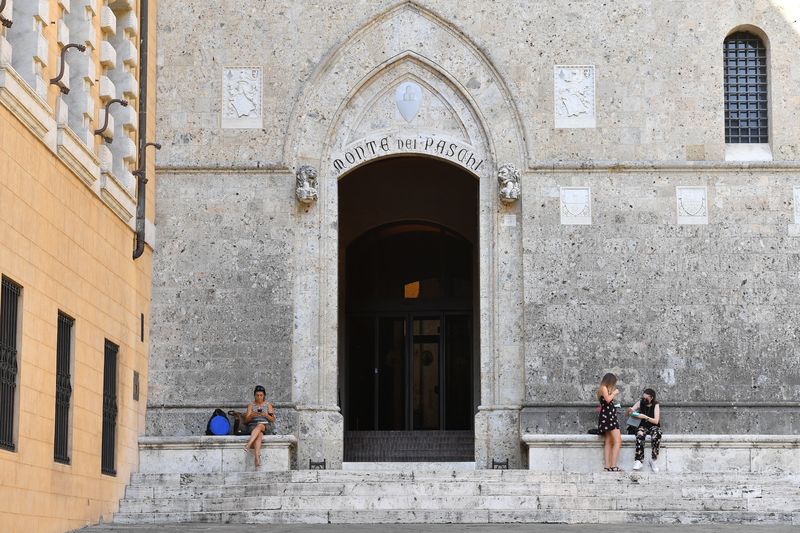 &copy; Reuters. People stay at Piazza Salimbeni entrance to the headquarters of Monte dei Paschi di Siena (MPS), the oldest bank in the world, which is facing massive layoffs as part of a planned corporate merger, in Siena, Italy, August 11, 2021.   REUTERS/Jennifer Lore