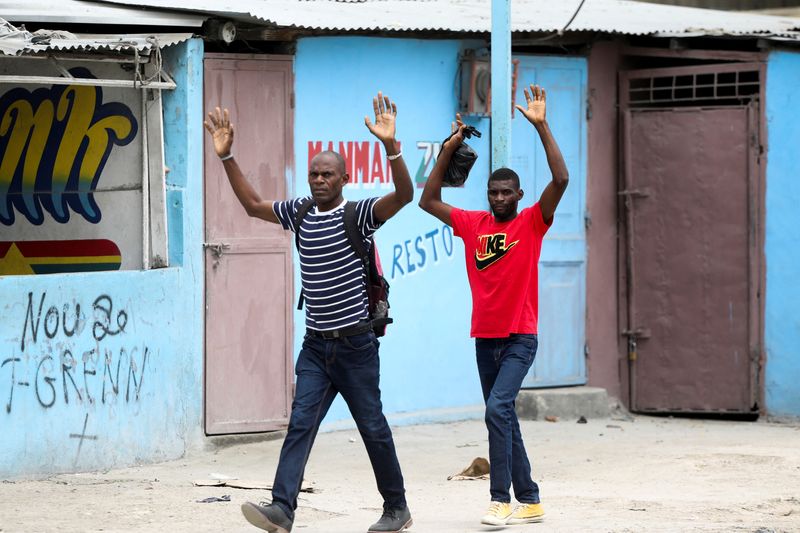 &copy; Reuters. Residentes levantas sus brazos mientras escapan de sus casas debido a las batallas armadas en curso entre pandillas rivales, en Puerto Príncipe, Haití. 2 de mayo, 2022. REUTERS/Ralph Tedy Erol