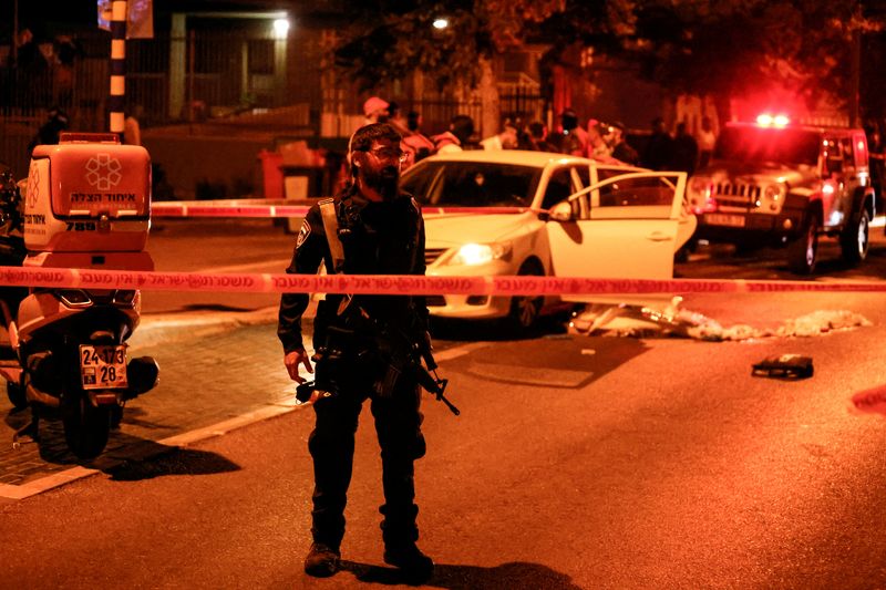 © Reuters. ضابط شرطة إسرائيلي يعمل في موقع الهجوم الذي وقع في مدينة إلعاد بوسط إسرائيل يوم الخميس. تصوير: عمار عوض - رويترز