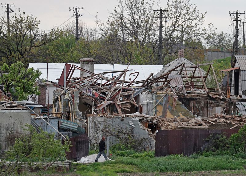 &copy; Reuters. A local resident walks past houses destroyed during Ukraine-Russia conflict in the southern port city of Mariupol, Ukraine May 5, 2022. Picture taken May 5, 2022. REUTERS/Alexander Ermochenko