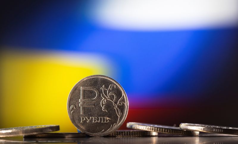 © Reuters. Russian Rouble coins are seen in front of displayed Ukrainian's and Russia's flag colours in this illustration taken, February 24, 2022. REUTERS/Dado Ruvic/Illustration/Files