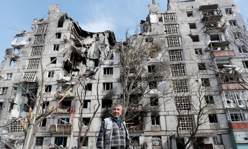 &copy; Reuters. Un uomo davanti a diversi palazzi distrutti dai bombardamenti a Mariupol. REUTERS/Alexander Ermochenko