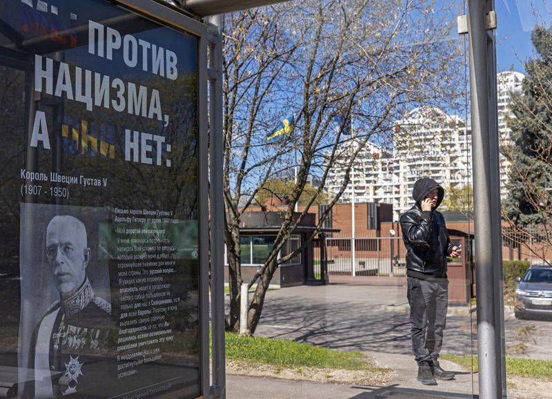 &copy; Reuters. Un póster con un retrato del rey Gustavo V de Suecia y el mensaje "Nosotros estamos contra el nazismo, ellos no" escrito en caracteres cirílicos en una marquesina de autbús junto a la embajada sueca en Moscú, Rusia, el 5 de mayo de 2022. REUTERS/FOTÓ