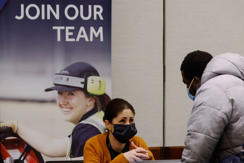&copy; Reuters. FILE PHOTO: A job seeker talks to a representative from Signature Flight Support at a job fair for airport related employment at Logan International Airport in Boston, Massachusetts, U.S., December 7, 2021.   REUTERS/Brian Snyder