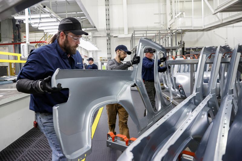 © Reuters. Employees work on an assembly line at startup Rivian Automotive's electric vehicle factory in Normal, Illinois, U.S. April 11, 2022. Picture taken April 11, 2022.  REUTERS/Kamil Krzaczynski