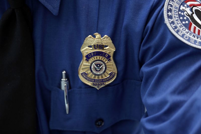 &copy; Reuters. FILE PHOTO: A Transportation Security Administration (TSA) official's wears a TSA badge at Terminal 4 of JFK airport in New York City, U.S., May 17, 2017. REUTERS/Joe Penney