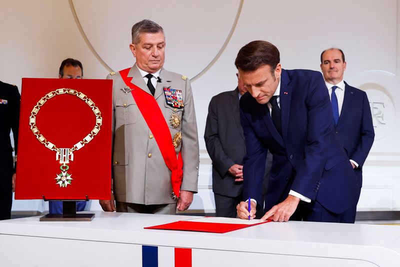 &copy; Reuters. France's Military Chief of Staff to the presidency Benoit Puga stands next to French President Emmanuel Macron signing a document as he is sworn-in for a second term as president after his re-election, during a ceremony at the Elysee Palace in Paris, Fran