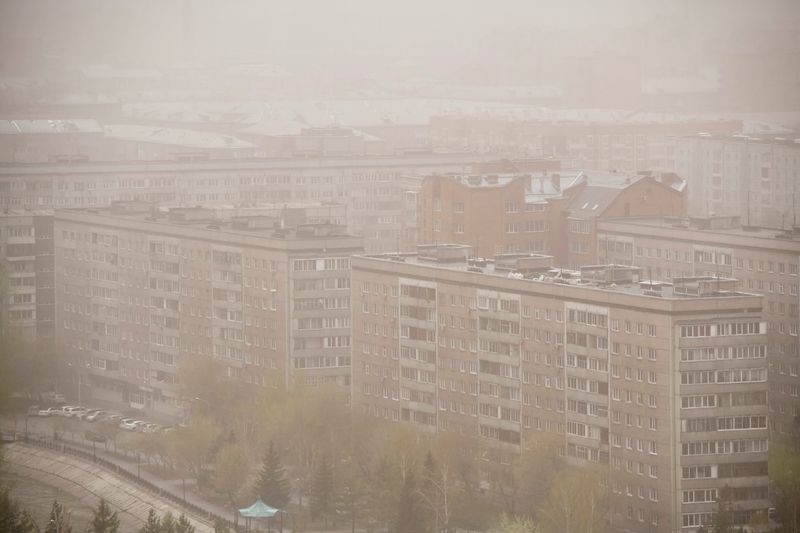 &copy; Reuters. لقطة عامة لمبان سكنية يغطيها دخان حرائق الغابات في مدينة كراسنويارسك في سيبيريا في شرق روسيا يوم السبت. تصوير: رويترز.