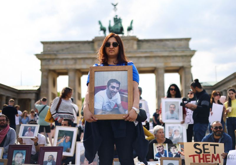 &copy; Reuters. روجين دركي تحمل صورة شقيقها محمد في اعتصام نظمه نشطاء سوريون في برلين يوم السبت. تصوير: كريستيان مانج - رويترز