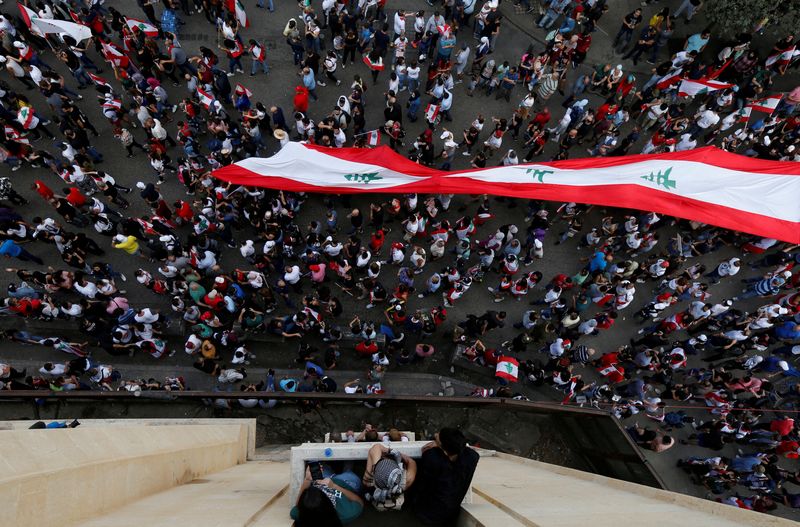 &copy; Reuters. FILE PHOTO: Demonstrators carry a giant national flag during an anti-government protest in downtown Beirut, Lebanon October 20, 2019. REUTERS/Mohamed Azakir/File Photo
