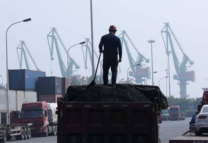 &copy; Reuters. A labourer loads coal in a truck next to containers outside a logistics center near Tianjin Port, in northern China, May 16, 2019. REUTERS/Jason Lee/Files