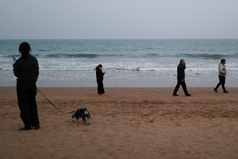 &copy; Reuters. FOTO DE ARCHIVO. Imagen referencial de un grupo de personas caminando por la playa, en Qingdao, provincia de Shandong, China. 28 de abril de 2021. REUTERS/Carlos García Rawlins