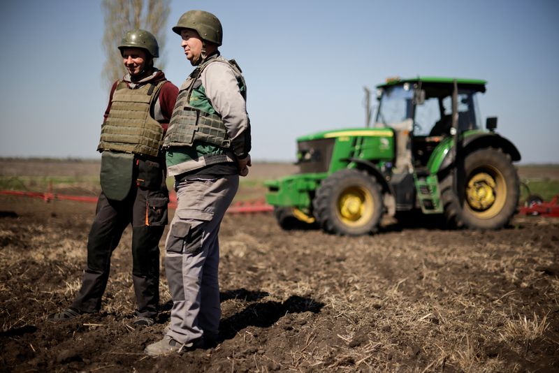 &copy; Reuters. FOTO DE ARQUIVO-Yuri e Oleksiy, agricultores ucranianos vestindo coletes e capacetes à prova de balas, trabalham no solo superficial de um campo, em meio à invasão russa da Ucrânia, na região de Zaporizhia, na Ucrânia. 26 de abril de 2022. REUTERS/U