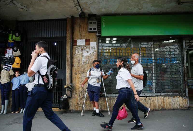 © Reuters. Arquimedes Marquez, 64, a retired employee of the Ministry of Land Transport, stands on a street selling lighters and face masks to increase his pension, in Caracas, Venezuela May 6, 2022. Picture taken May 6, 2022. REUTERS/Leonardo Fernandez Viloria