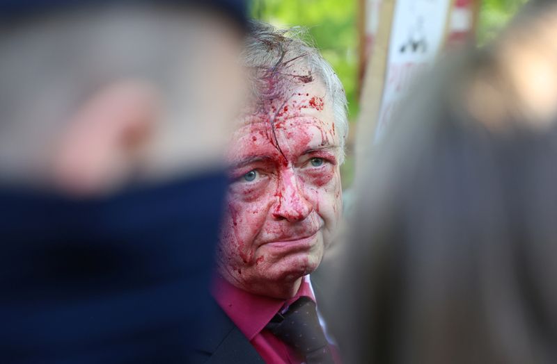&copy; Reuters. ポーランドの首都ワルシャワで９日、旧ソ連兵墓地に献花に訪れたロシアのアンドレーエフ駐ポーランド大使が、ウクライナ侵攻に反対する抗議者グループに赤い液体を掛けられる騒ぎがあ