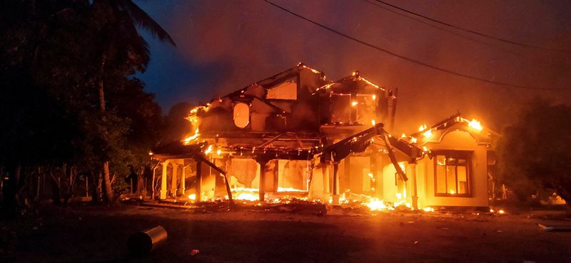 © Reuters. Anti-government demonstrators set fire on the house owned by minister Sanath Nishantha of resigned Prime Minister Mahinda Rajapaksa's cabinet after ruling party supporters stormed anti-govt protest camp, amid the country's economic crisis, in Arachchikattuwa, Sri Lanka, April May 9, 2022. REUTERS/Stringer  