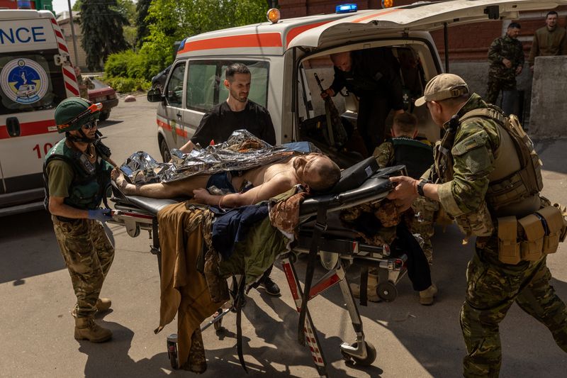 &copy; Reuters. Paramedics from the Pirogov First Volunteer Mobile Hospital move an injured Ukrainian solider, who was evacuated from the front line in Popasna, from an ambulance, amid Russia's invasion in Ukraine, outside a hospital in Bakhmut, Donetsk region, Ukraine, 