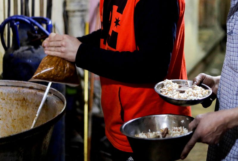 &copy; Reuters. FOTO DE ARCHIVO: Un hombre toma alimentos preparados para comer durante el Iftar, una comida para terminar el ayuno al atardecer, en el Cairo, 20 de abril de 2022. REUTERS/Mohamed Abd El Ghany