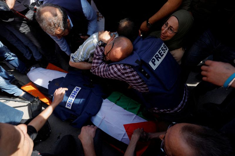 &copy; Reuters. Un grupo de personas, incluidos varios periodistas, reaccionan junto al cadáver de la periodista Shireen Abu Akleh tras su asesinato por disparos israelíes, según dijo el canal de noticias qatarí Al Jazeera, durante un asalto de las fuerzas de Israel 