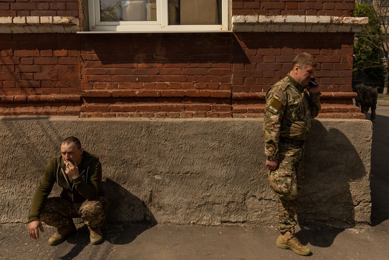 © Reuters. Soldiers suffering from shell-shock after duty on the front line, amid Russia's invasion in Ukraine, smoke outside the emergency room at a hospital in Bakhmut, Donetsk region, Ukraine, May 5, 2022. REUTERS/Jorge Silva     