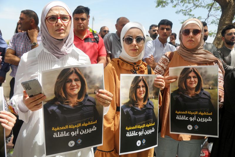 © Reuters. Palestinians hold pictures of Al Jazeera reporter Shireen Abu Akleh, who was killed by Israeli army gunfire during an Israeli raid, according to the Qatar-based news channel, in Nablus in the Israeli-occupied West Bank May 11, 2022. Israeli military said Abu Akleh may have been shot by Palestinians as they clashed with its troops. REUTERS/Raneen Sawafta