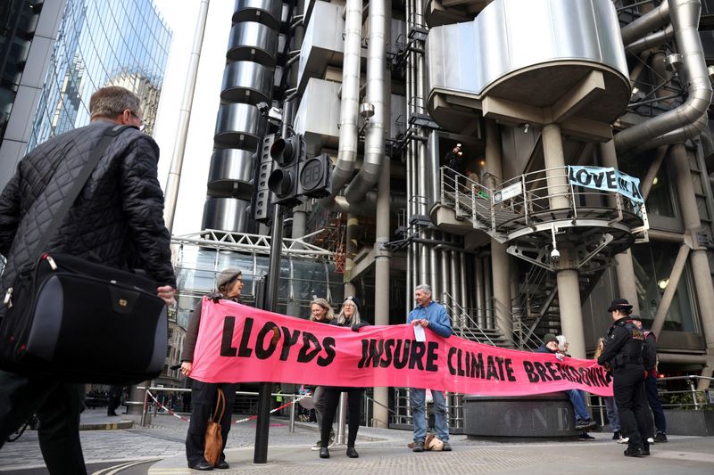 © Reuters. FILE PHOTO: Activists from Extinction Rebellion hold a banner outside the Lloyd's of London building, in the City of London financial district, in London, Britain, April 12, 2022. REUTERS/Henry Nicholls/File Photo