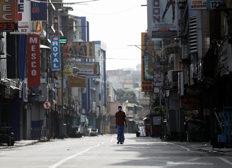 &copy; Reuters. A man walks along a deserted road after the curfew was extended  for another extra day following a clash between Anti-government demonstrators and Sri Lanka's ruling party supporters, amid the country's economic crisis, in Colombo, Sri Lanka, May 11, 2022