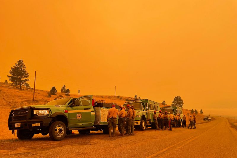 © Reuters. Smoke casts an orange haze as firefighters hold a briefing in the Black Lake, New Mexico area north of the Calf Canyon Hermits Peak wildfire, U.S., May 11, 2022. REUTERS/Andrew Hay