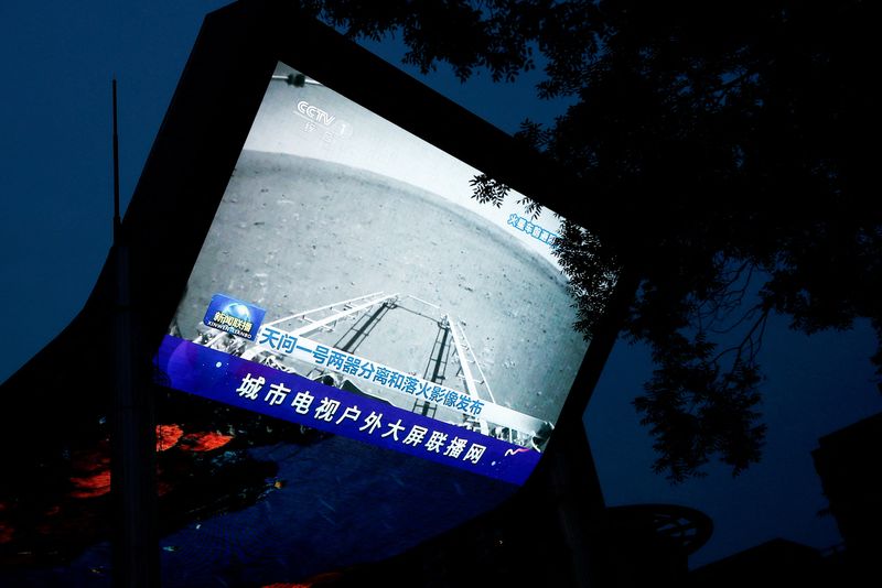 &copy; Reuters. FOTO DE ARCHIVO: Una pantalla emite un boletín de noticias de los medios estatales CCTV, mostrando una imagen de Marte tomada por el rover chino Zhurong como parte de la misión Tianwen-1, en Pekín, China, el 19 de mayo de 2021. REUTERS/Thomas Peter/Fil