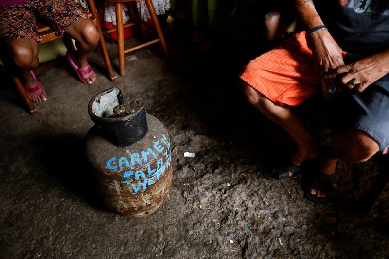 &copy; Reuters. FILE PHOTO: Members of a family sit next to an old gas canister, with a name written on it, at his home in the low-income neighbourhood of Petare, in Caracas,  Venezuela April 30, 2022. REUTERS/Gaby Oraa NO RESALES. NO ARCHIVES