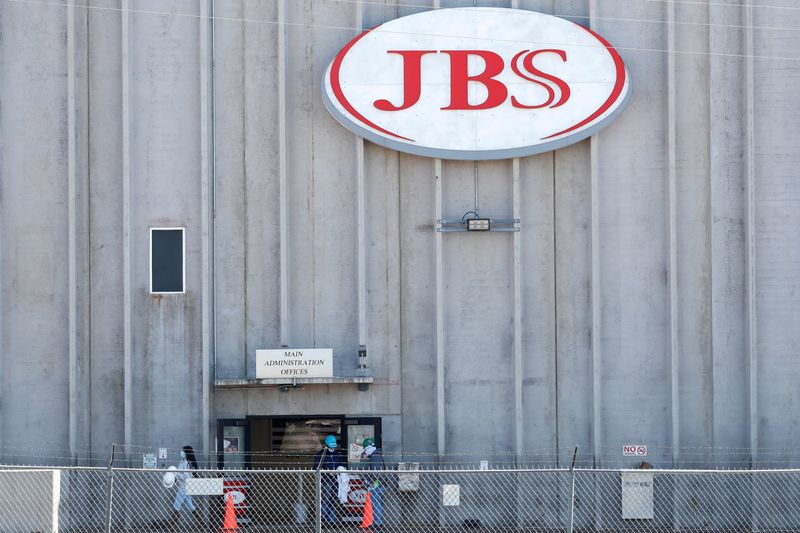 &copy; Reuters. FILE PHOTO: Employees walk around with face masks at the JBS USA meat packing plant, which on Monday was closed after numerous employees tested positive and two have died from the coronavirus disease (COVID-19), in Greeley, Colorado, U.S., April 14, 2020.
