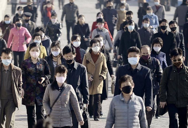 &copy; Reuters. Pessoas de máscara caminham por rua de Pyongyang, na Coreia do Norte
30/03/2020
Kyodo/via REUTERS