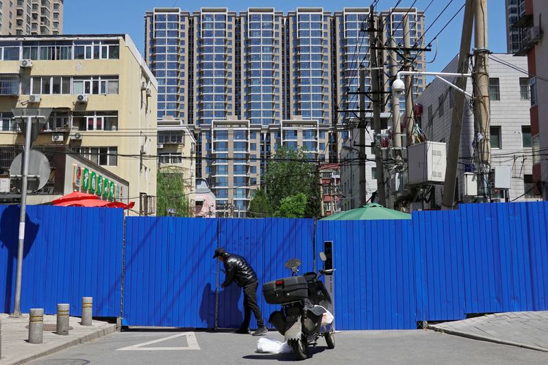 &copy; Reuters. Un hombre hace entregas en una zona residencial atrincherada bajo confinamiento en medio del brote de la enfermedad del coronavirus (COVID-19) en Pekín, China. 13 de mayo de 2022. REUTERS/Thomas Suen