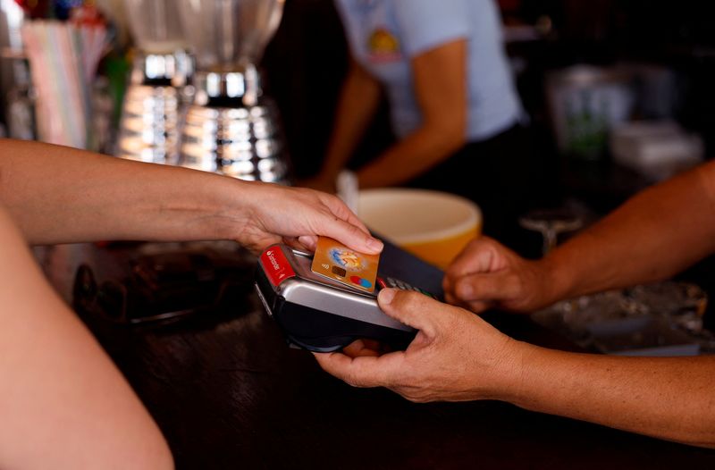 &copy; Reuters. FILE PHOTO: A woman pays with a credit card at a restaurant in Playa del Ingles, Maspalomas on the island of Gran Canaria, Spain, May 3, 2022.  REUTERS/Borja Suarez
