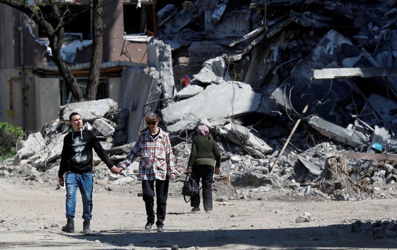 &copy; Reuters. FOTO DE ARCHIVO: Residentes locales junto a un edificio destruido durante el conflicto entre Ucrania y Rusia en la ciudad portuaria del sur de Mariúpol, Ucrania, 12 de mayo de 2022. REUTERS/Alexander Ermochenko    