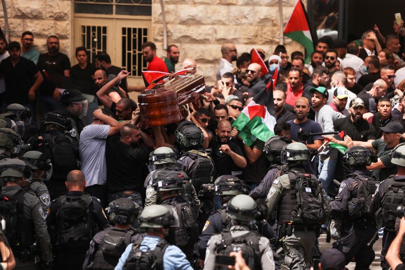 © Reuters. أفراد من قوات الأمن الإسرائيلية يشتبكون مع مشيعون يحملون جثمان شيرين أبو عاقلة في القدس يوم الجمعة. تصوير: عمار عوض - رويترز.