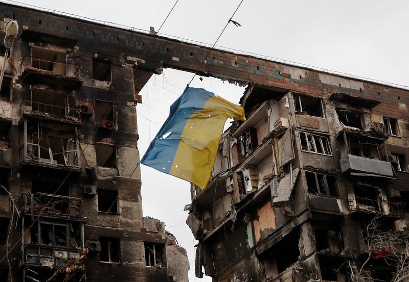 &copy; Reuters. FOTO DE ARCHIVO: Una bandera rota de Ucrania colgada en un cable frente a un edificio de apartamentos destruido durante el conflicto entre Ucrania y Rusia en la ciudad portuaria del sur de Mariúpol, Ucrania 14 de abril de 2022. REUTERS/Alexander Ermochen