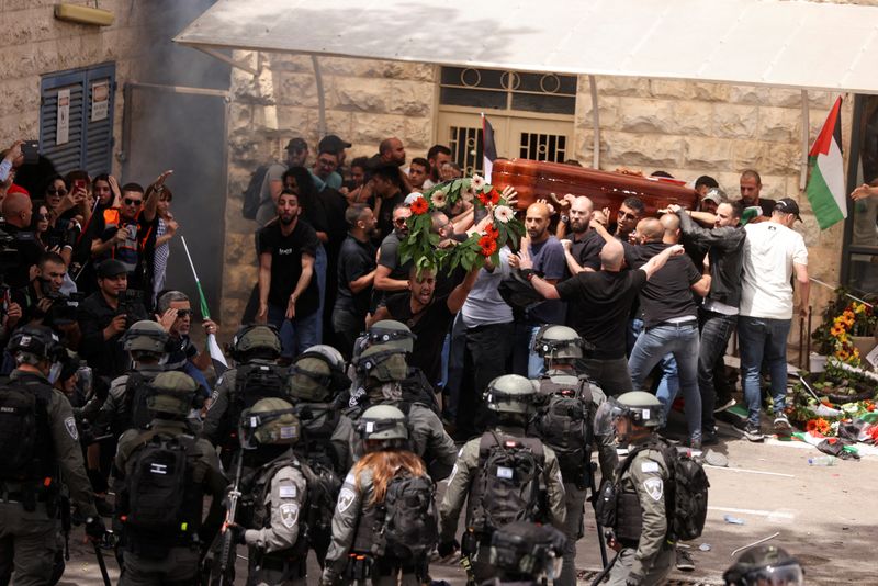 &copy; Reuters. مشيعون يحملون جثمان صحفية الجزيرة القتيلة شيرين أبو عاقلة في مواجهة قوات أمن إسرائيلية في القدس يوم الجمعة. تصوير: عمار عوض - رويترز.