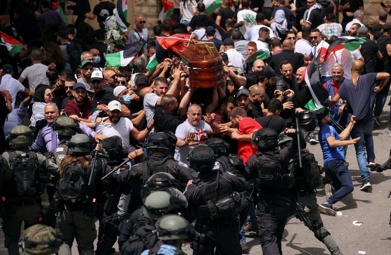 © Reuters. Family and friends carry the coffin of Al Jazeera reporter Shireen Abu Akleh, who was killed during an Israeli raid in Jenin in the occupied West Bank, as clashes erupted with Israeli security forces, during her funeral in Jerusalem, May 13, 2022. REUTERS/Ammar Awad