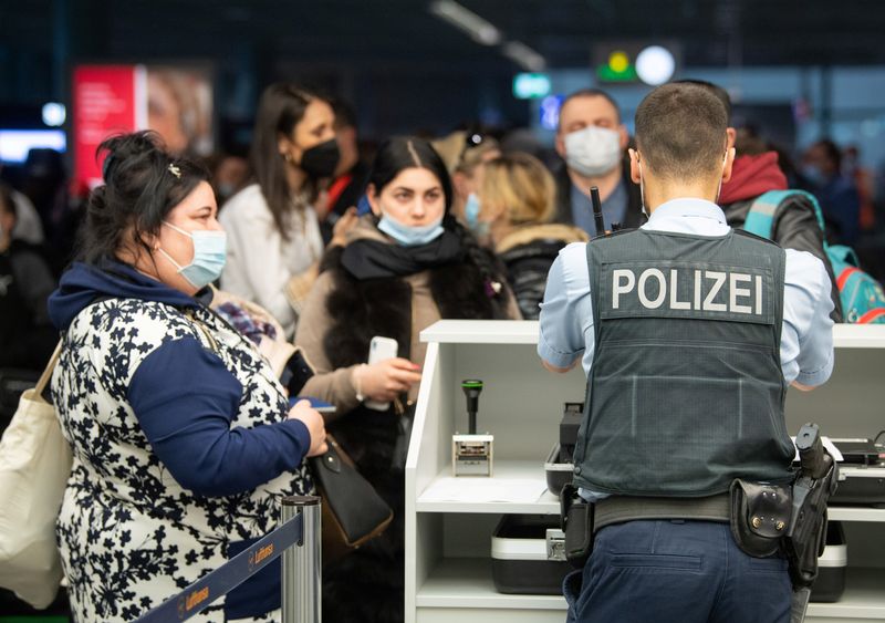 &copy; Reuters. ضابط شرطة ألماني يفحص وثائق لاجئين أوكرانيين في مطار فرانكفورت في 25 مارس آذار 2022. صورة لرويترز من ممثل لوكالات الأنباء.