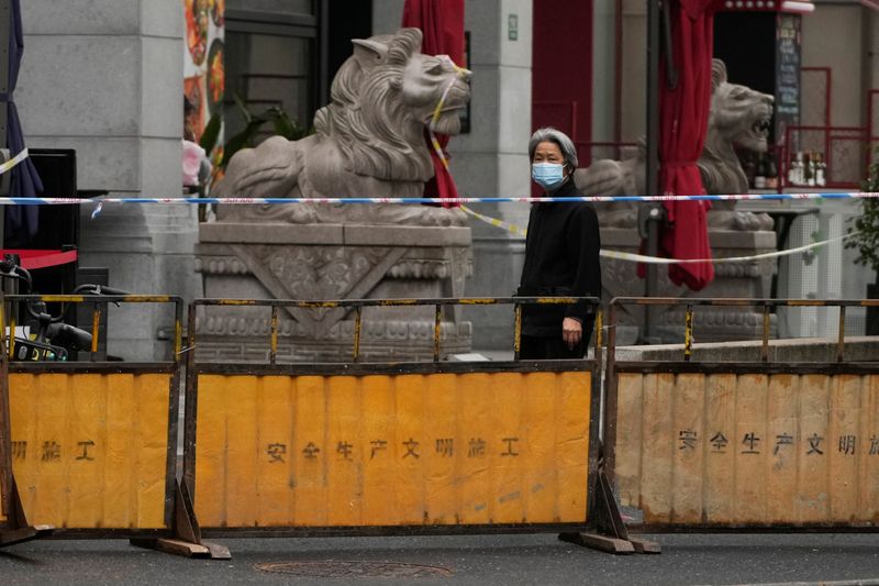 &copy; Reuters. سيدة صينية تسير في أحد الشوارع المغلقة خلال فرض إجراءات الإغلاق في شنغهاي بالصين لمواجهة وباء فيروس كورونا يوم الجمعة. تصوير: ألي سونغ - رويت