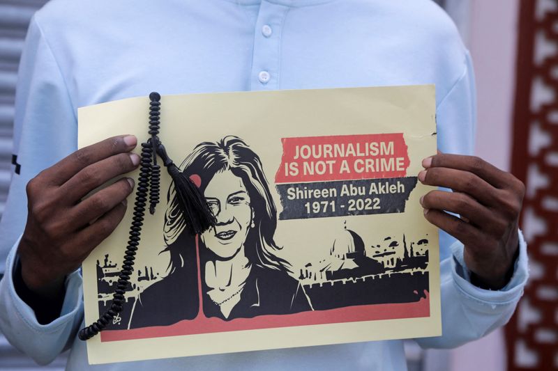 &copy; Reuters. صحفية في مقديشو تحمل لافتة عليها صورة لصحفية الجزيرة شيرين أبو عاقلة للتنديد بمقتلها أثناء تغطيتها مداهمة إسرائيلية في جنين بالضفة الغربية