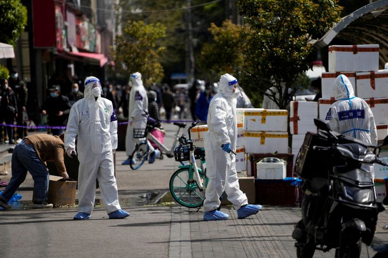 &copy; Reuters. FILE PHOTO: Police and security members in protective suits stand outside cordoned off food stores following the coronavirus disease (COVID-19) outbreak in Shanghai, China March 29, 2022. REUTERS/Aly Song