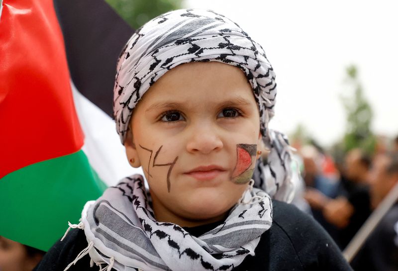 &copy; Reuters. طفلة، طلي أحد خديها بألوان العلم الفلسطيني وكتب على الآخر رقم 74، تشارك في مسيرة لإحياء الفلسطينيين الذكرى الرابعة والسبعين للنكبة في رام ال
