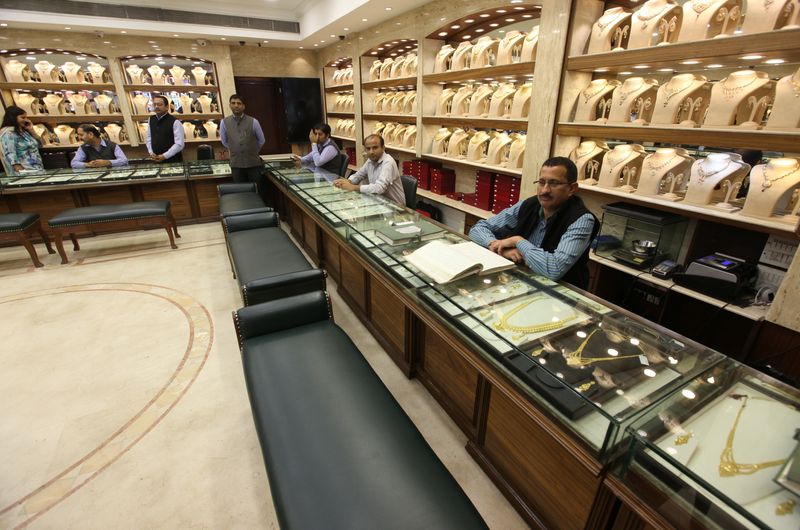 © Reuters. FILE PHOTO: Sales persons wait for customers at a gold jewelry showroom in Chandigarh, India, November 9, 2016. REUTERS/Ajay Verma